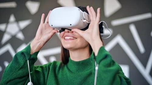 A young woman is excited while wearing VR glasses. Slow motion