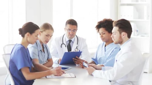 Multiethnic doctors meeting discussing medical app at hospital conference