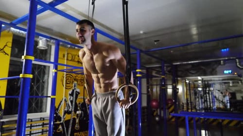 Strong Athlete Doing Push Ups on Gymnastic Rings at Sport Club Muscular Shirtless Sportsman