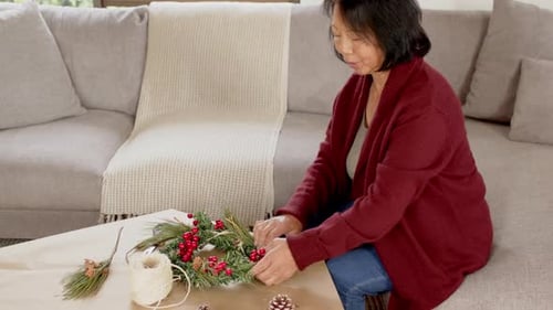 Woman Making Festive Holiday Wreath at Home