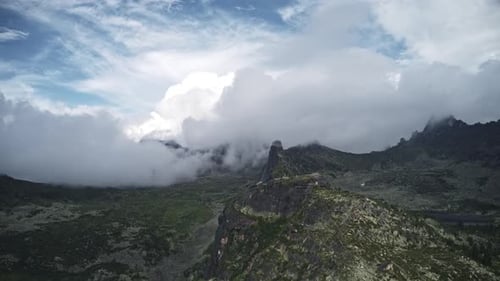 Aerial View of Rocky Mountain Peaks Through Clouds