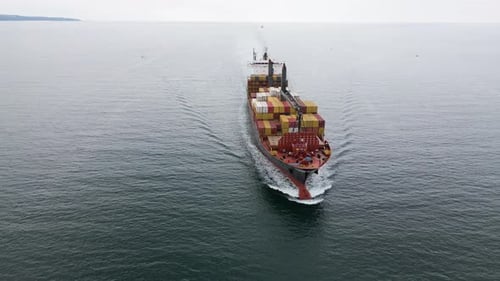 Aerial View of a Large Cargo Ship Carrying Colorful Containers Approaching the Port Maritime