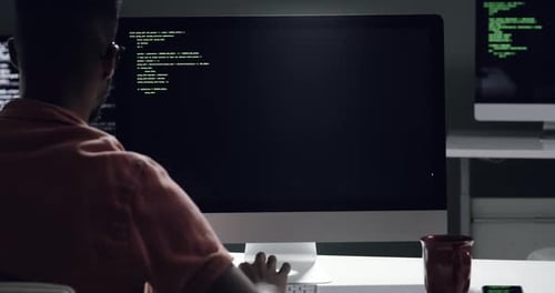 Man Programming at Desk Working Late at Night