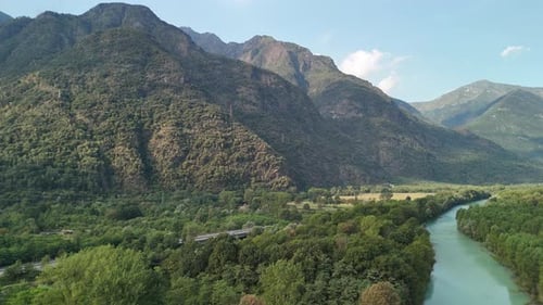 Drohnenaufnahme der Berge und des Flusses, der entlang der Straße fließt.