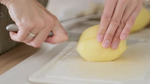 Woman Cutting Potatoes on the Board Cooking Vegetables Dinner in Kitchen Close Up of Females Hands
