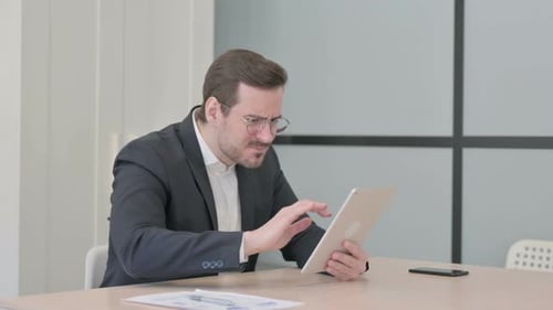 Man Using Tablet Has Problem at Desk