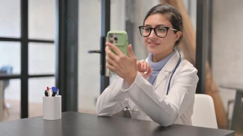 Online Video Chat by Female Indian Doctor on Phone in Clinic