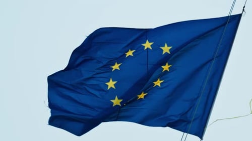 Nahaufnahme der wehenden Flagge der Europäischen Union mit blauem Himmel im Hintergrund