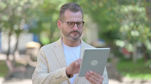 Man Using Tablet for Video Call Outside
