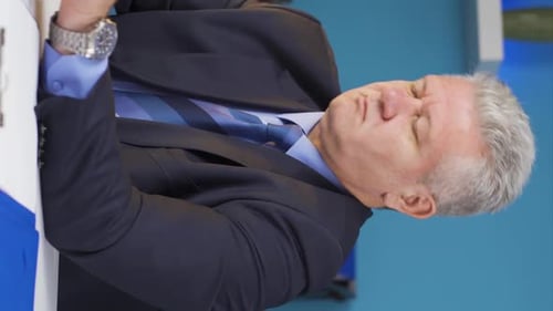 Stressed Man Rubbing Shoulder in Workplace