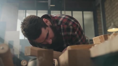 Carpenter working with pouch in moody workshop