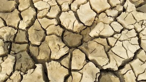 A close-up shot of broken soil due to the drought shows the impact of climate change on the environm