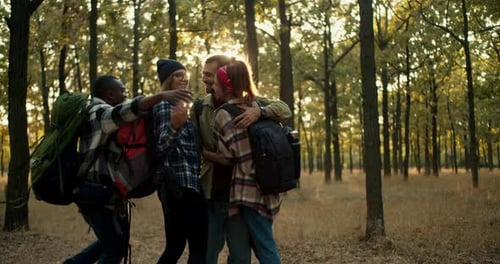 A Group of Happy Friends on a Hike Run Up to Each Other and Hug People in Hiking Clothes with