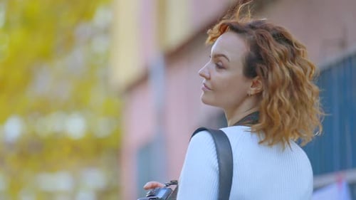 Woman Walks and Smiles with Camera