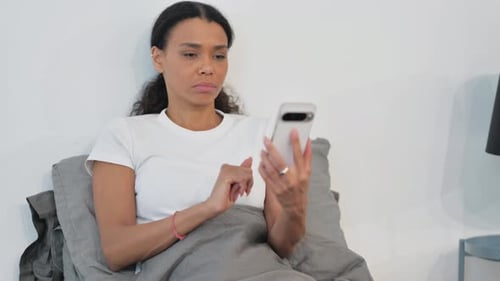 Woman Uses Smartphone in Bed at Home