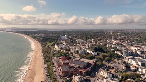 Bournemouth, vuelo a lo largo del paseo marítimo sobre el centro de conferencias, la ciudad y la playa hacia