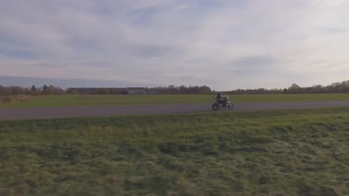 A Man Riding A Motorcycle In The Fall. Aerial Tracking Shot.
