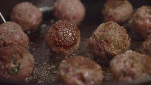 El chef convierte las albóndigas fritas en una sartén caliente con aceite de cocina hirviendo. Toma a cámara lenta. Cocinar