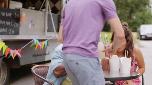 Friends Enjoying Food Truck Meal Together Outdoors