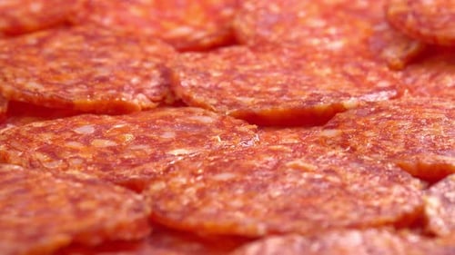 Juicy sliced pepperoni sausage rotating as background for restaurant, food video, food porn. Smoke