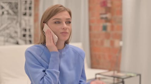 Young Woman Talking on Smartphone Indoors
