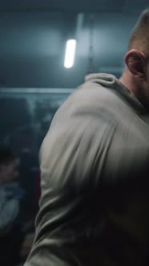 Male Boxer in Boxing Bandages Trains and Hits Punching Bag