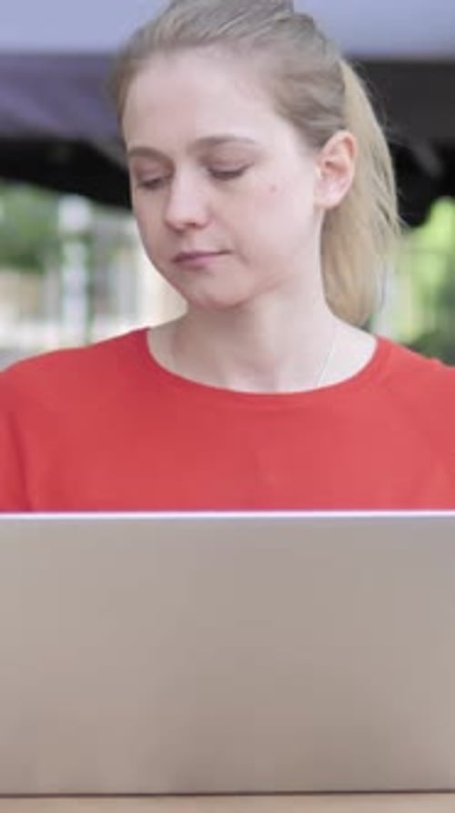 Young Woman Working on Laptop and Drinking Coffee Sitting in Cafe Terrace, Vertical Video