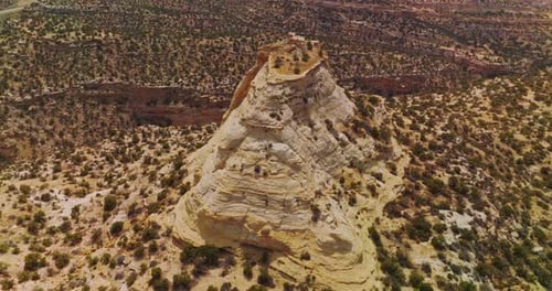 Nackter Fels mit flacher Spitze inmitten der Wüstenlandschaft. Utah-Nationalpark mit spärlichem Grün.