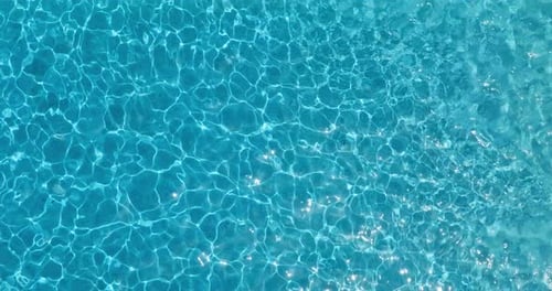 Blue Water in the Swimming Pool with Light Reflections