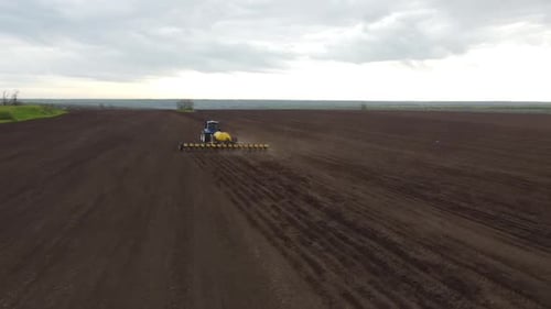 Blue tractor OA working on the field in Ukraine