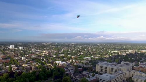 A party balloon slowly deflating and falling from the skies over the city of Tacoma WA, USA - Aerial