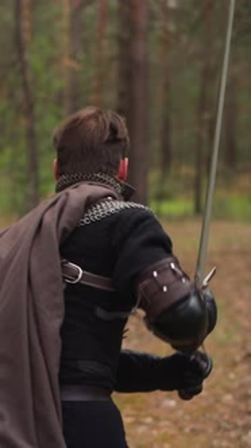 Strong Knight Holds Sword Running Through Forest Backside