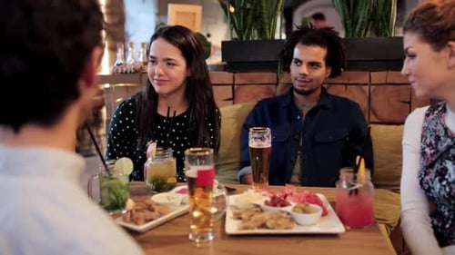 Friends Enjoying Drinks and Conversation at a Bar