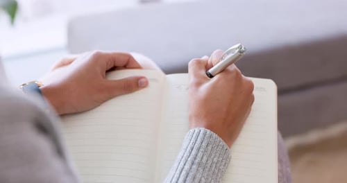 Writing in Notebook with Silver Pen Indoors