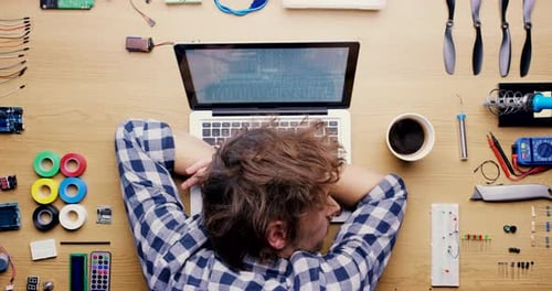 Person Programming on Laptop at Desk with Components