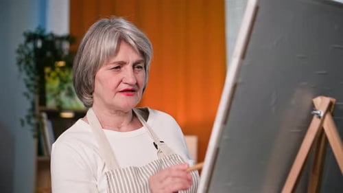 Senior Woman Painting on Canvas in Studio