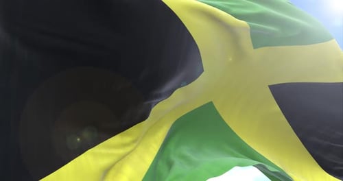 Realistic Waving Jamaican Flag Against Blue Sky