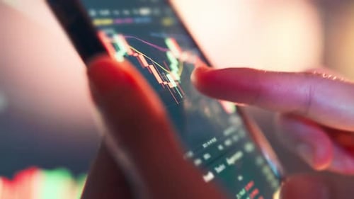 Woman is checking Bitcoin price chart on digital exchange on smartphone.