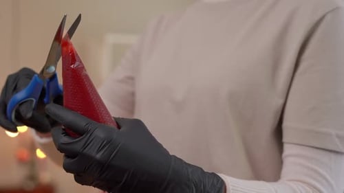 Person Cuts Pastry Bag Full of Red Filling