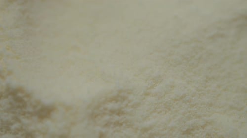 Milk powder falls gracefully into the container capturing the process
