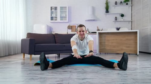 Man Stretching on Mat in Bright Home