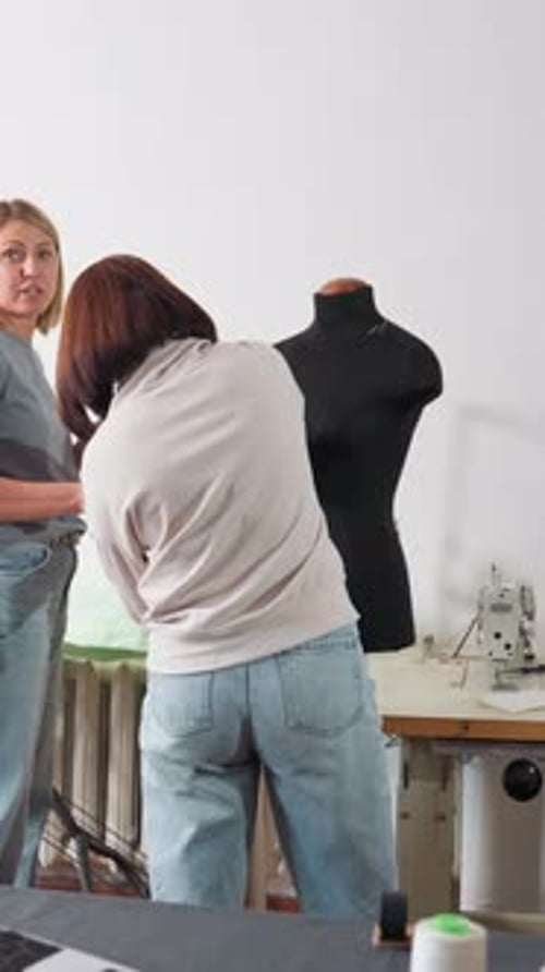 Modekünstler arbeiten zusammen, um Textilien auf der Ausstellungsform auszurichten, Designer und Näherinnen stimmen sich ab