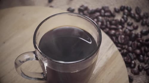 Steaming Mug of Coffee with Roasted Coffee Beans