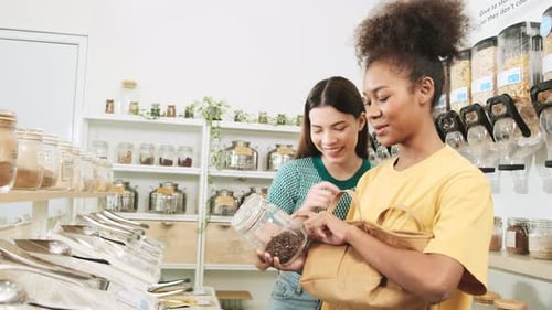 Two young women shopped in refill store, reusable bags, and zero-waste grocery.