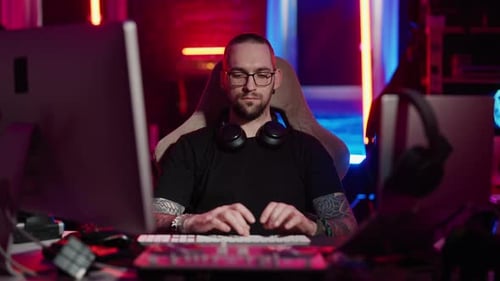 Young Adult Typing at Computer in Brightly Lit Room