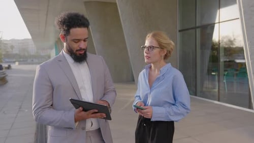 Man and Woman Talk, Look at Tablet