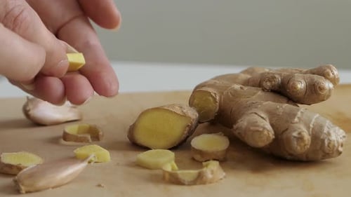 Fresh ginger ang garlic, picking up sliced ginger and garlic, close up