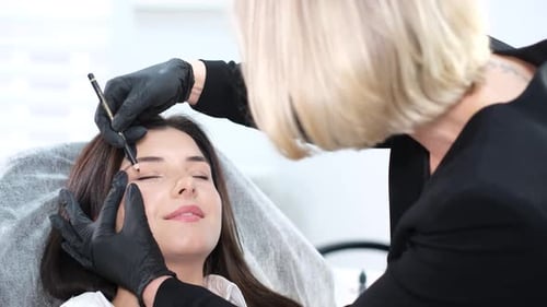 Woman Getting Eyebrows Done at Beauty Salon