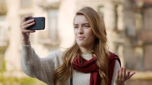 Cheerful Woman Video Chatting on Phone in City