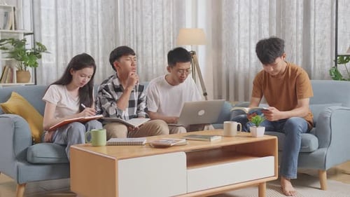 Young Adults Studying Together on Sofa